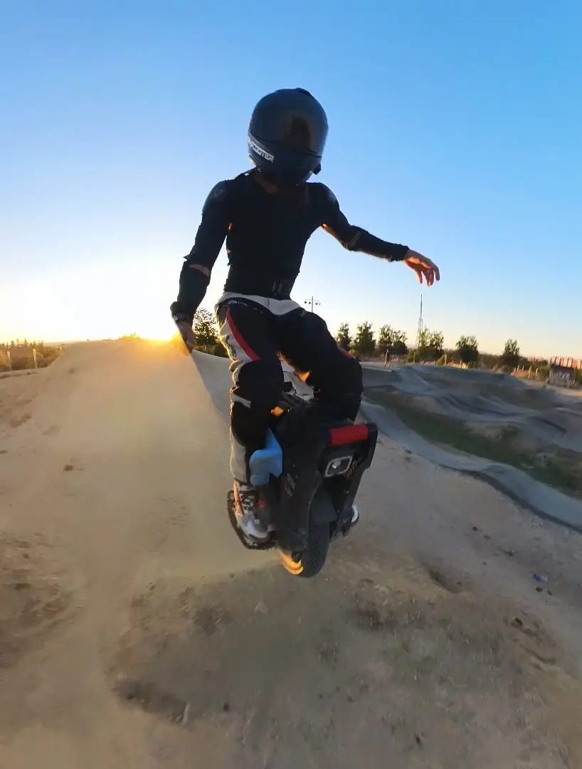 Kjører hopper med en elektrisk enhjuling Sherman L på en pumptrack i solnedgang
